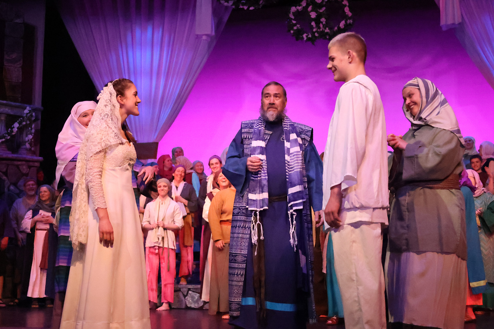 A rabbi speaks to a bride and groom.